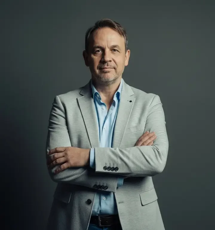 Robert Linsbauer mit verschränkten Armen vor dunklem Hintergrund
